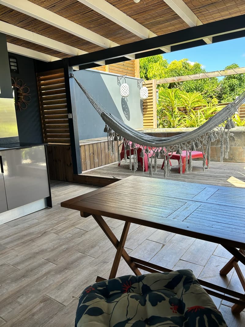 La table en bois de la terrasse, le hamac derrière